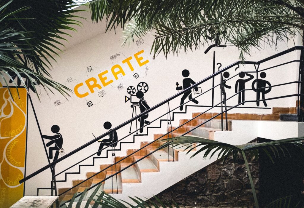 Mural featuring creative stick figures on a staircase with lush greenery.